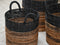Woven baskets with black and brown stripes on a light background