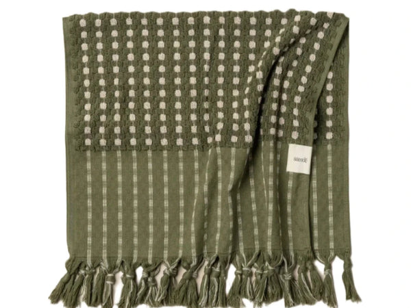 A green and beige striped saarde bath towel with a fringed edge