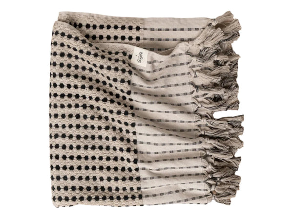 A folded bath sheet with a geometric pattern in black and gray tones, made of Turkish cotton, displayed on a white background.