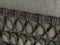 Close-up of a green woven seat cover with a black frame