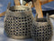 Two woven baskets with a geometric pattern on a textured surface.