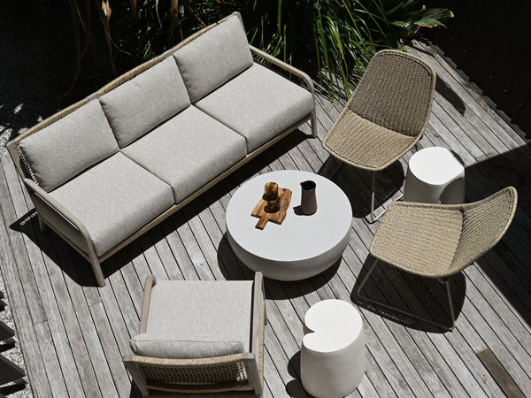 Outdoor furniture set with sofa, chairs, and table on a wooden deck.