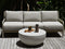 Gray outdoor sofa with a white round table on a wooden deck