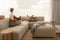 Modern living room with beige sectional sofa, wooden coffee table, and TV.