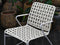 White wicker chair on a wooden deck with potted plants in the background