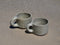Two ceramic mugs on a sandy surface