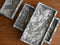 Small, medium and large marble trays on a wooden surface