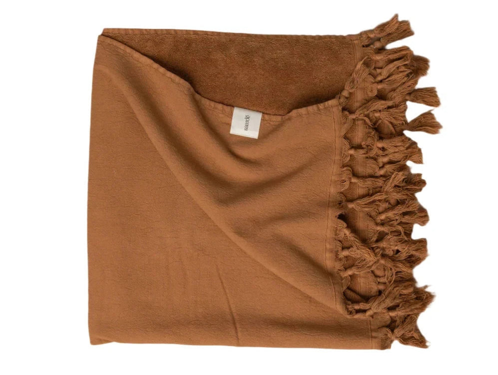 A brown terracotta vintage wash towel with fringes and a visible brand tag.